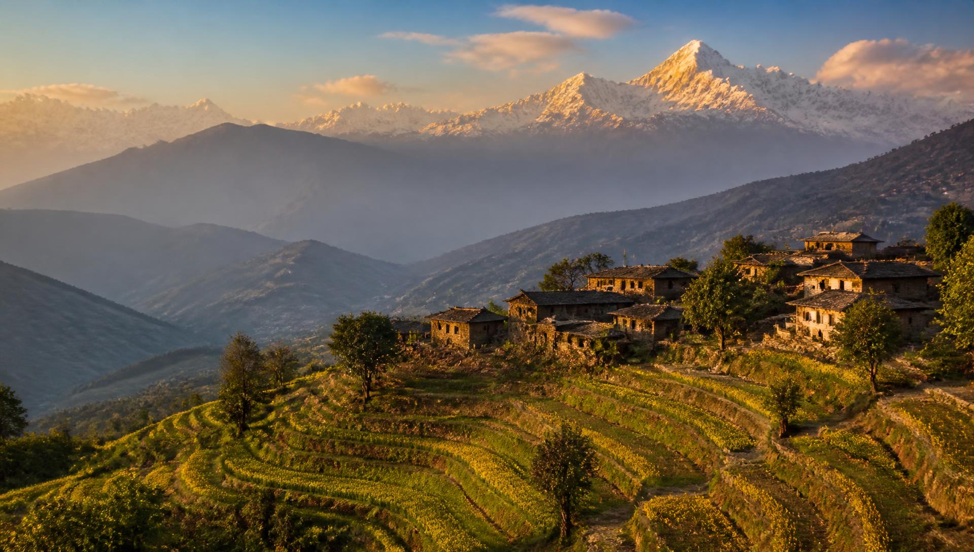 Terraced hillside village below the snow-capped Himalaya at sunrise, Nepal